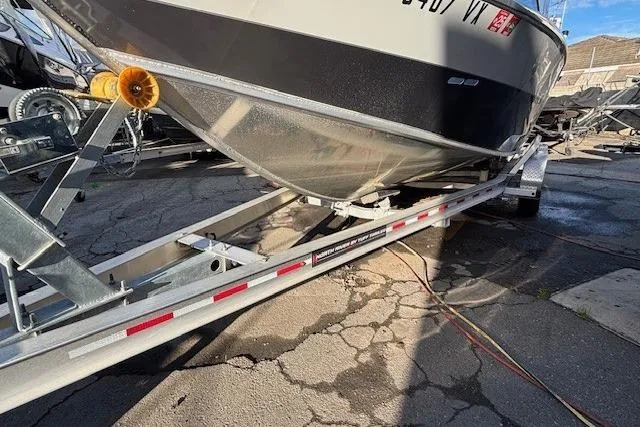 Slide: The Image of 2023 North River 23' Seahawk boat on trailer, parked on cracked pavement. - 3