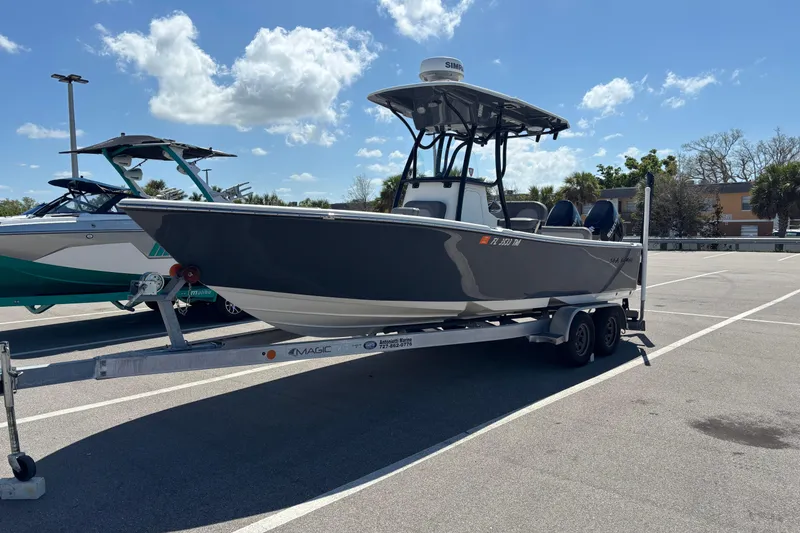 The Image of 2023 Sea Born LX24 Center Console boat on trailer in parking lot under blue sky. - 0