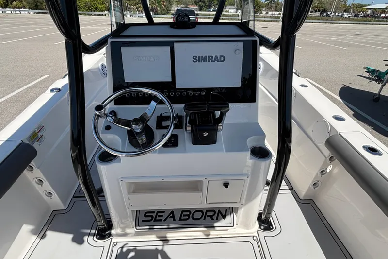 Slide: The Image of 2023 Sea Born LX24 Center Console boat interior with steering wheel and Simrad displays. - 11