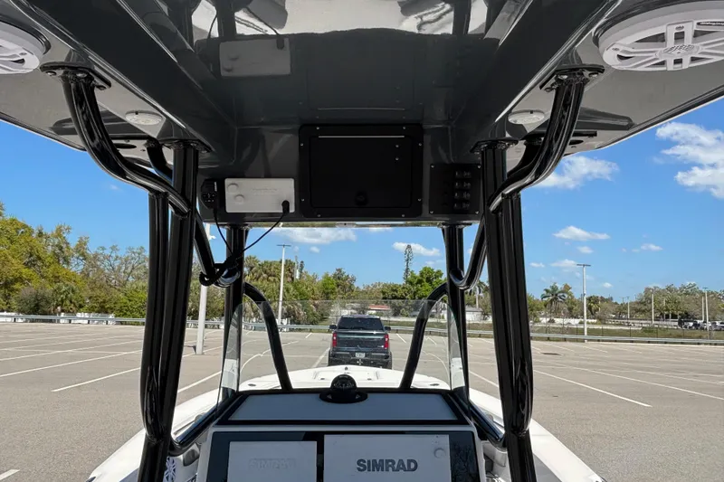 Slide: The Image of 2023 Sea Born LX24 Center Console boat interior with electronics and parking lot view. - 19