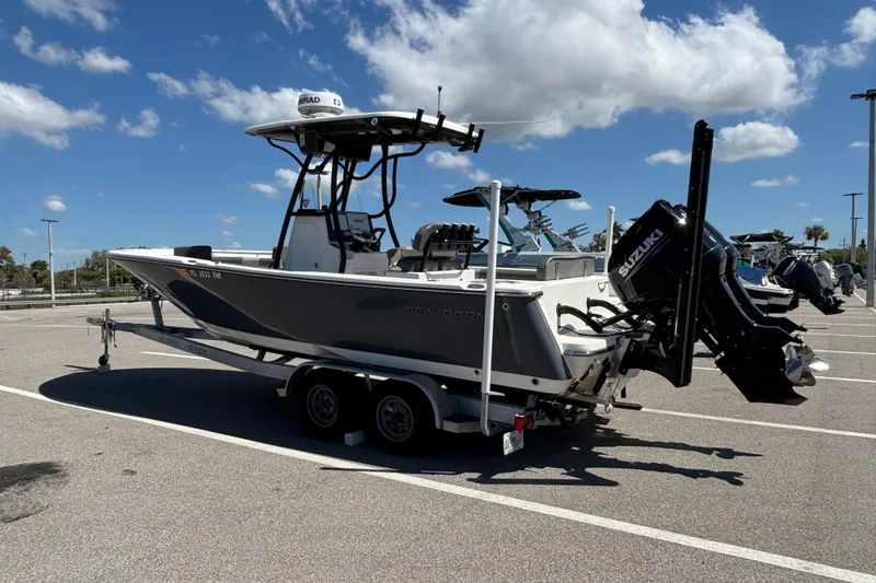 Slide: The Image of 2023 Sea Born LX24 Center Console boat on trailer in parking lot. - 2