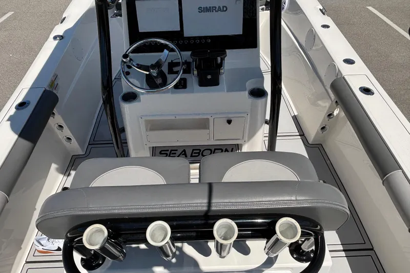 Slide: The Image of 2023 Sea Born LX24 Center Console boat interior with steering wheel and rod holders. - 20