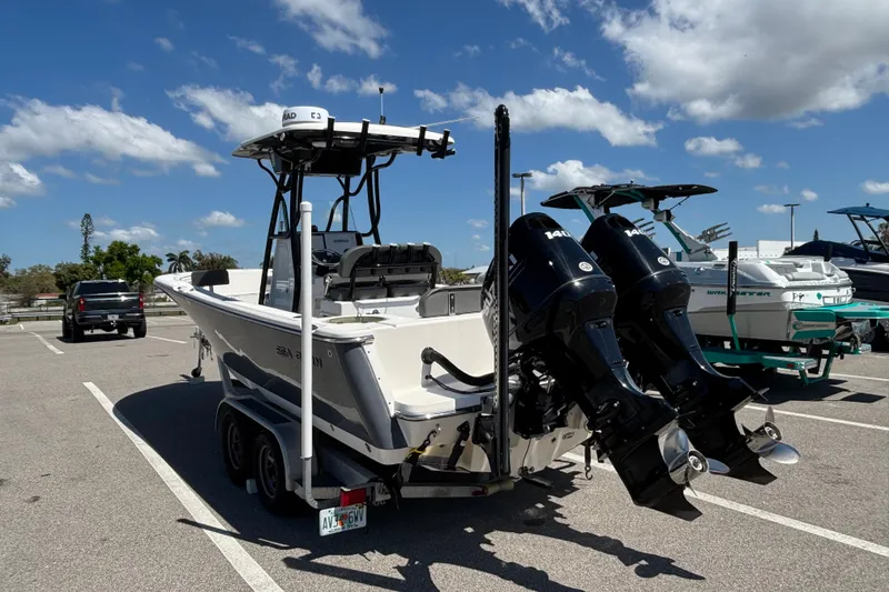 Slide: The Image of 2023 Sea Born LX24 Center Console boat with dual engines in a parking lot. - 8