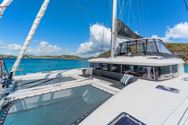 Slide: The Image of 2017 Lagoon 450 F catamaran on clear blue water, featuring spacious deck and seating area. - 11