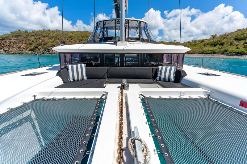 Slide: The Image of 2017 Lagoon 450 F catamaran with spacious deck, anchored in clear blue waters. - 12