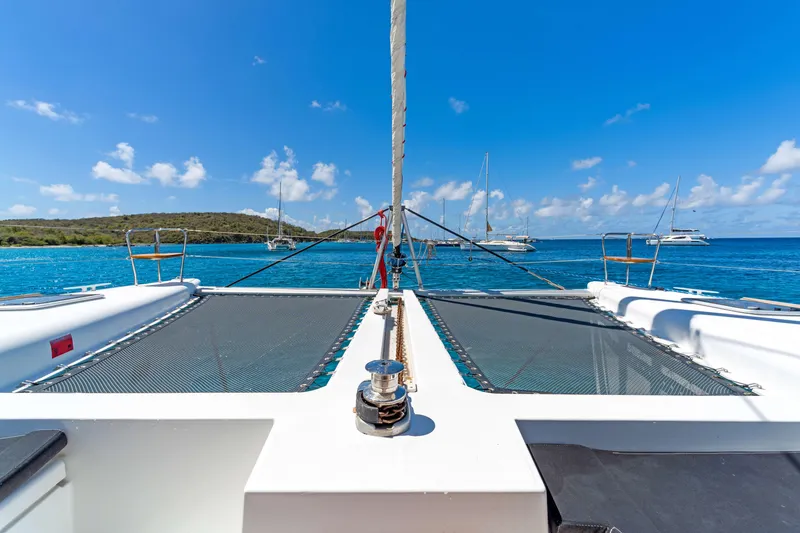 Slide: The Image of 2017 Lagoon 450 F catamaran on clear blue waters, with sailboats in the background. - 13