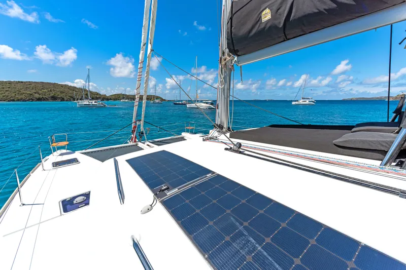 Slide: The Image of Lagoon 450 F catamaran sailing in clear blue waters, featuring solar panels on deck. - 16