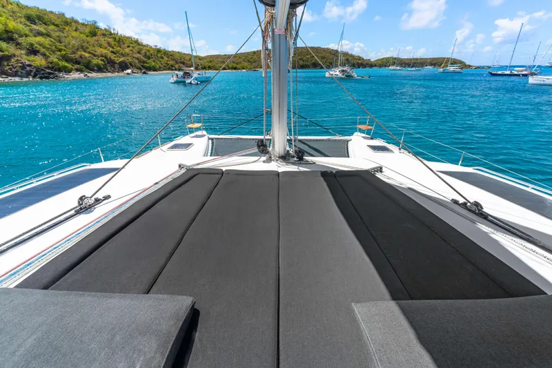 Slide: The Image of 2017 Lagoon 450 F catamaran with sunbathing area, anchored in turquoise waters. - 18