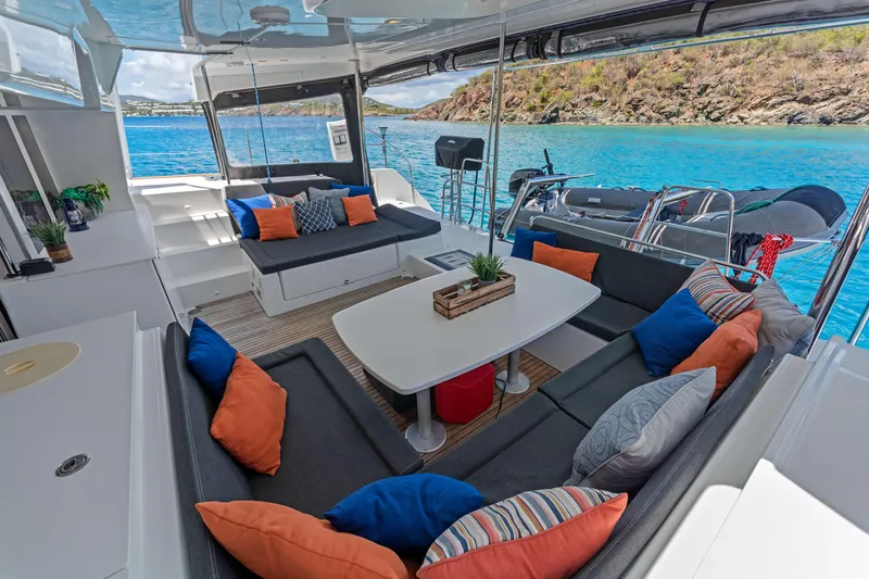 Slide: The Image of Luxurious Lagoon 450 F catamaran interior with colorful cushions, overlooking clear blue water. - 46