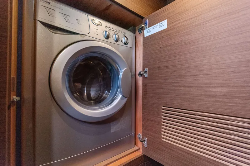 Slide: The Image of Built-in washing machine on Lagoon 450 F yacht, 2017 model, behind wooden cabinet door. - 73