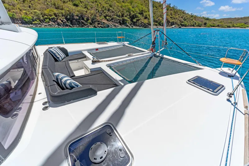 Slide: The Image of Luxurious Lagoon 450 F catamaran deck with seating, overlooking turquoise waters and lush coastline. - 8