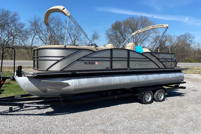 The Image of 2016 Starcraft MX 23 L pontoon boat on trailer, parked outdoors. - 0