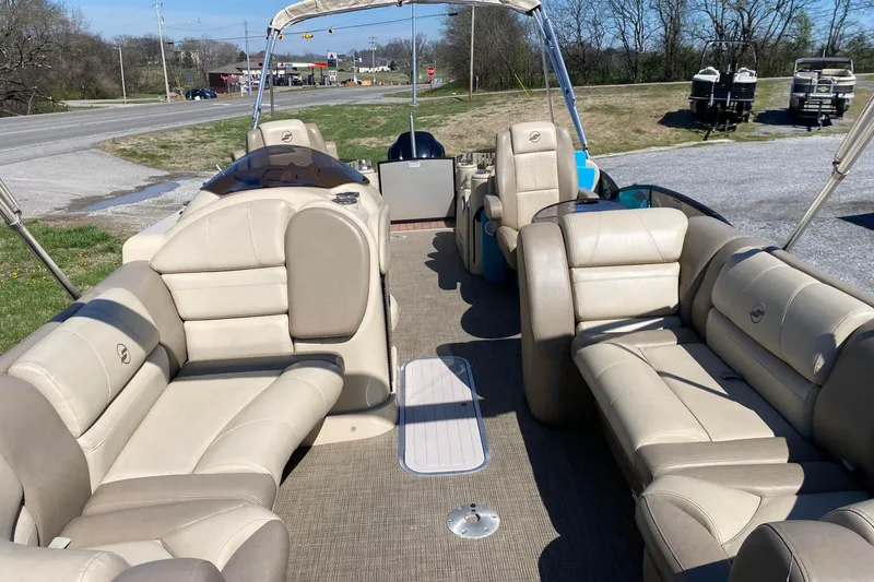 Slide: The Image of 2016 Starcraft MX 23 L pontoon boat with beige seating and open deck layout. - 3