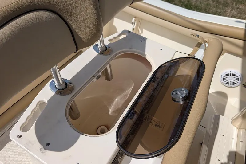 Slide: The Image of 2017 Scout 225 XSF boat interior with open storage compartment and beige seating. - 25