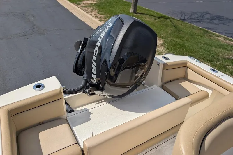 Slide: The Image of 2017 Scout 225 XSF boat with Mercury outboard motor, beige seating, parked on pavement. - 26