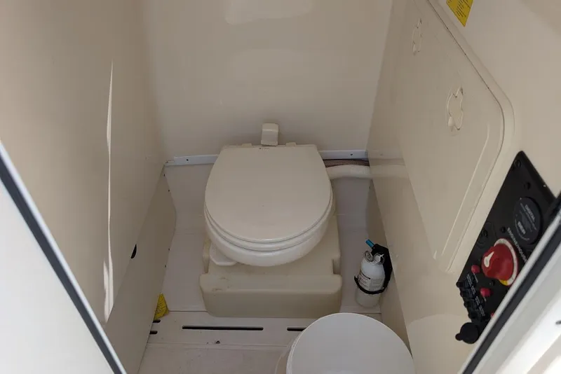 Slide: The Image of 2017 Scout 225 XSF boat interior with compact marine toilet and control panel. - 28