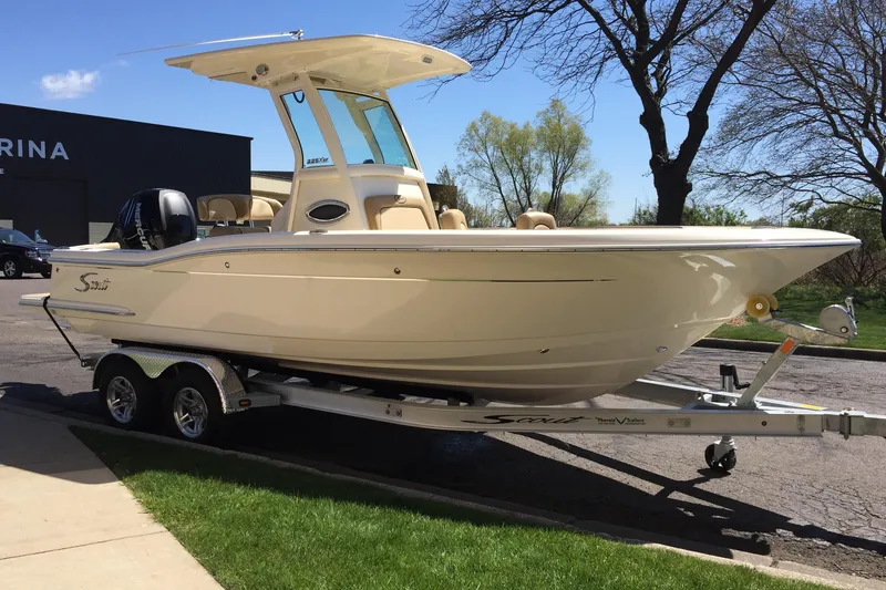 Slide: The Image of 2017 Scout 225 XSF boat on trailer, parked outdoors near marina. - 32