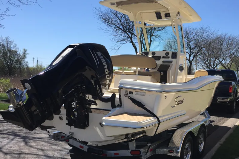 Slide: The Image of 2017 Scout 225 XSF boat on trailer with Mercury engine, parked outdoors. - 33