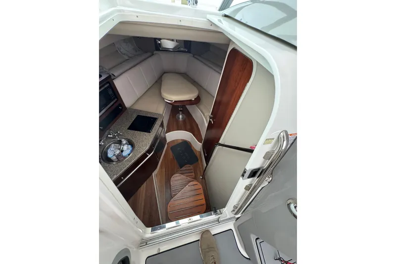 Slide: The Image of 2018 Robalo R305 Walkaround cabin interior with kitchenette and seating area. - 18