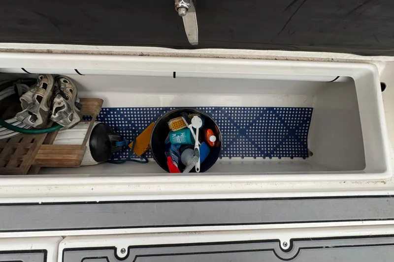 Slide: The Image of Storage compartment of 2018 Robalo R305 Walkaround boat with various boating accessories. - 20