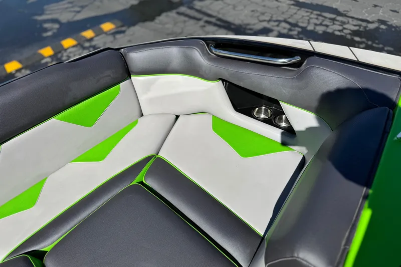 Slide: The Image of 2021 Moomba Kaiyen boat interior with green and gray seating, cup holders visible. - 12