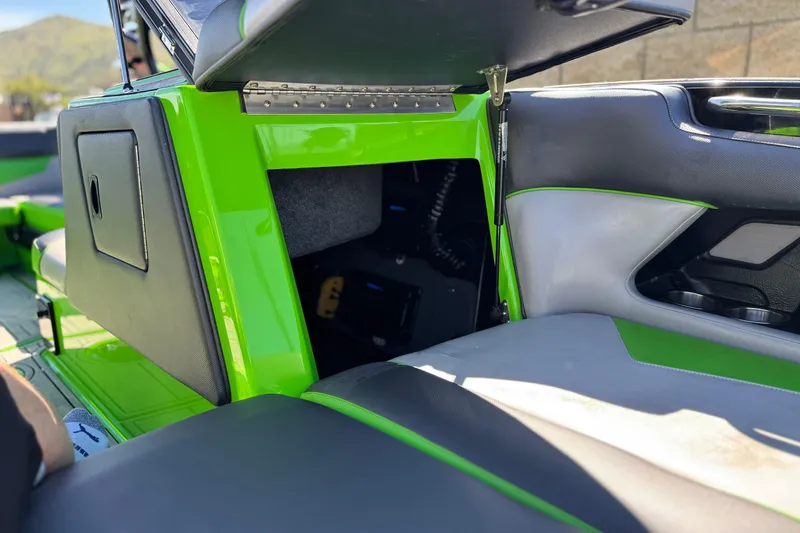 Slide: The Image of 2021 Moomba Kaiyen boat interior with open storage compartment, featuring green and gray seating. - 13
