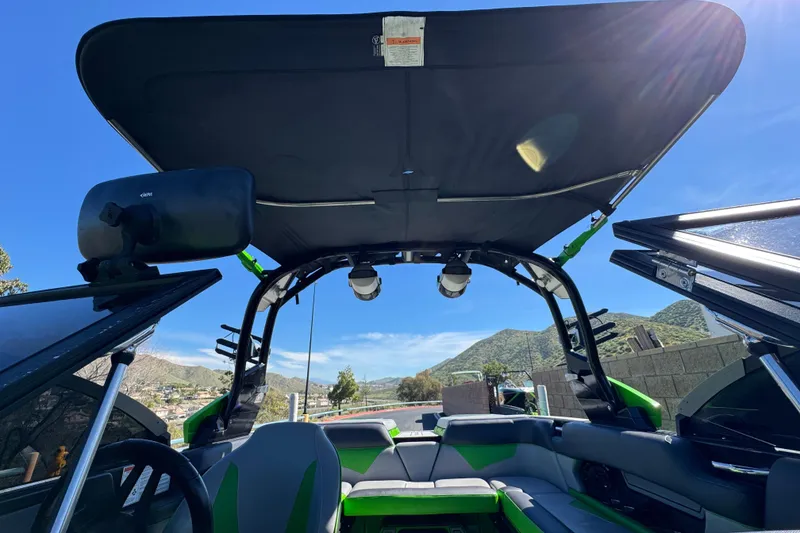 Slide: The Image of 2021 Moomba Kaiyen boat interior with open canopy, showcasing seating and scenic mountain view. - 15