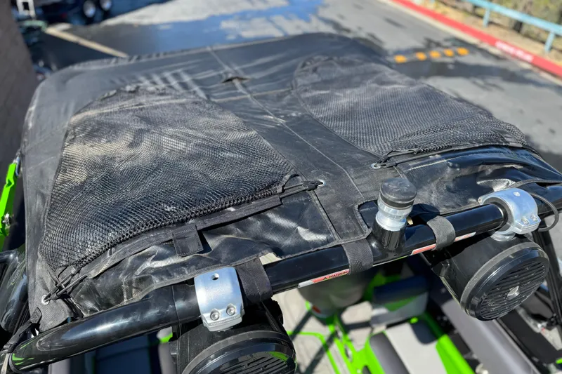 Slide: The Image of 2021 Moomba Kaiyen boat with black mesh cover and speakers on a sunny day. - 19