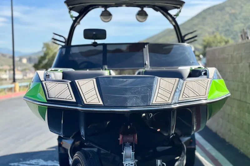 Slide: The Image of 2021 Moomba Kaiyen boat with sleek design and vibrant green accents. - 2