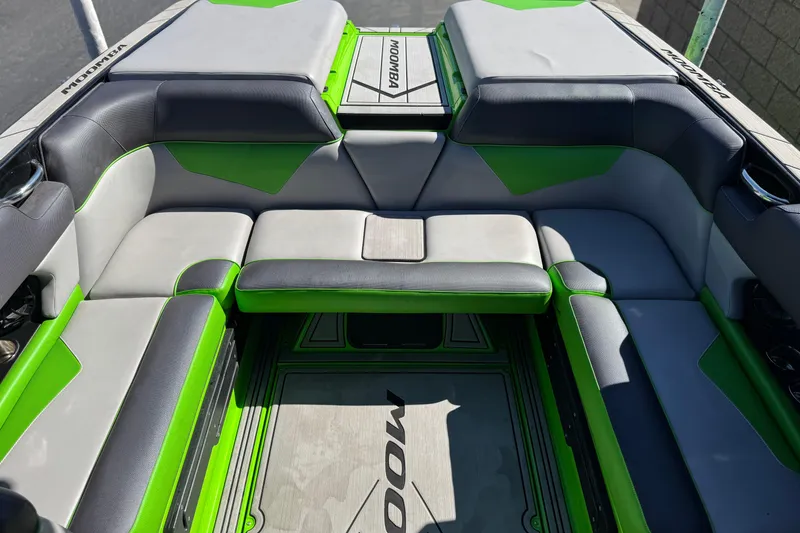 Slide: The Image of 2021 Moomba Kaiyen boat interior with green and gray seating, showcasing spacious design. - 21