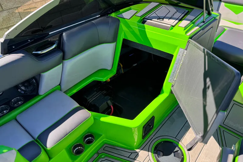 Slide: The Image of 2021 Moomba Kaiyen boat interior with vibrant green accents and open storage compartment. - 27