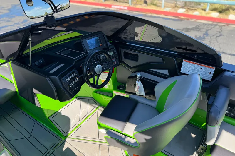 Slide: The Image of Interior of a 2021 Moomba Kaiyen boat with green accents and modern dashboard. - 31