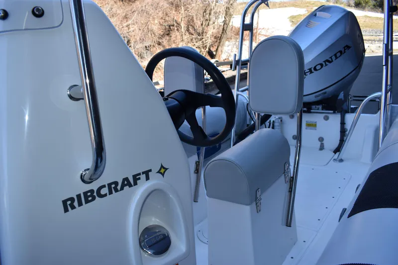 Slide: The Image of 2020 Ribcraft 5.85 boat interior with Honda engine, featuring steering wheel and seating. - 2