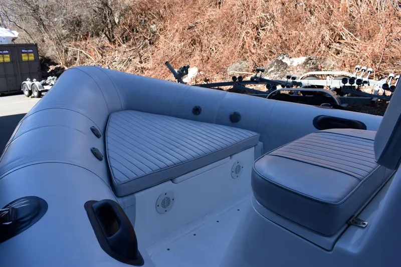 Slide: The Image of 2020 Ribcraft 5.85 inflatable boat interior with cushioned seating and storage compartments. - 5