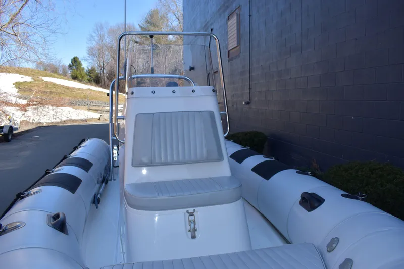 Slide: The Image of 2020 Ribcraft 5.85 inflatable boat with seating, docked near a building. - 6