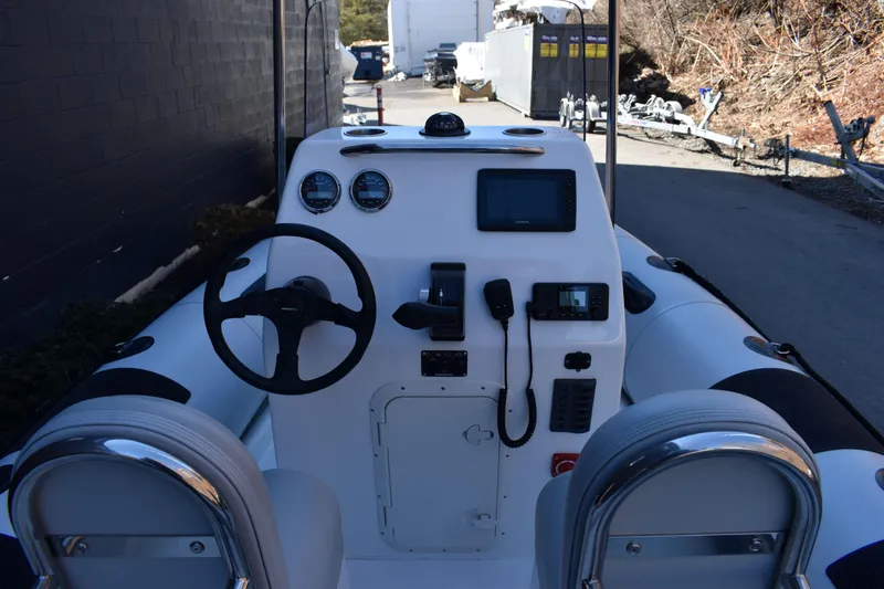 Slide: The Image of 2020 Ribcraft 5.85 boat dashboard with steering wheel and navigation instruments. - 8