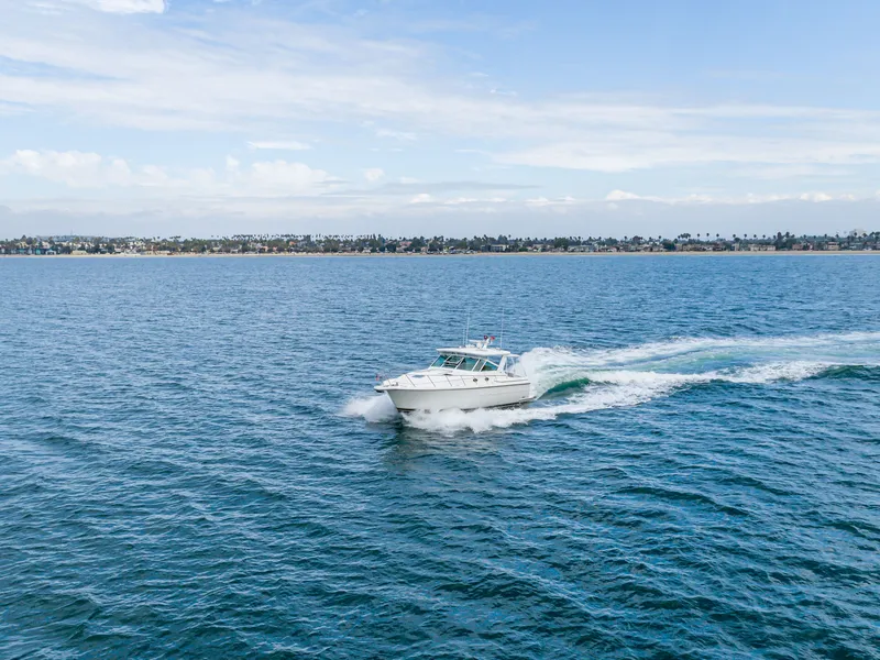 Slide: The Image of 2004 Tiara Yachts 4000 cruising on open sea, coastline in background. - 18