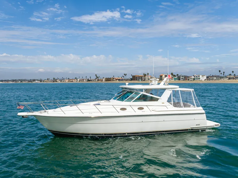 Slide: The Image of 2004 Tiara Yachts 4000 cruising on water near coastline. - 4