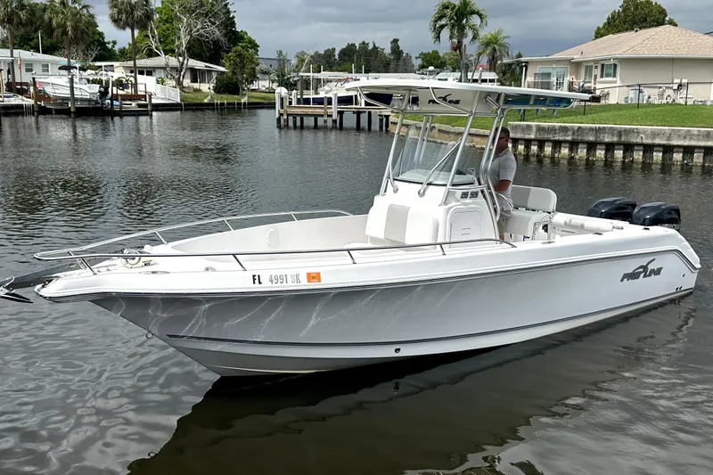 The Image of 2014 Pro-Line 26 Super Sport boat on calm water, dockside view. - 0
