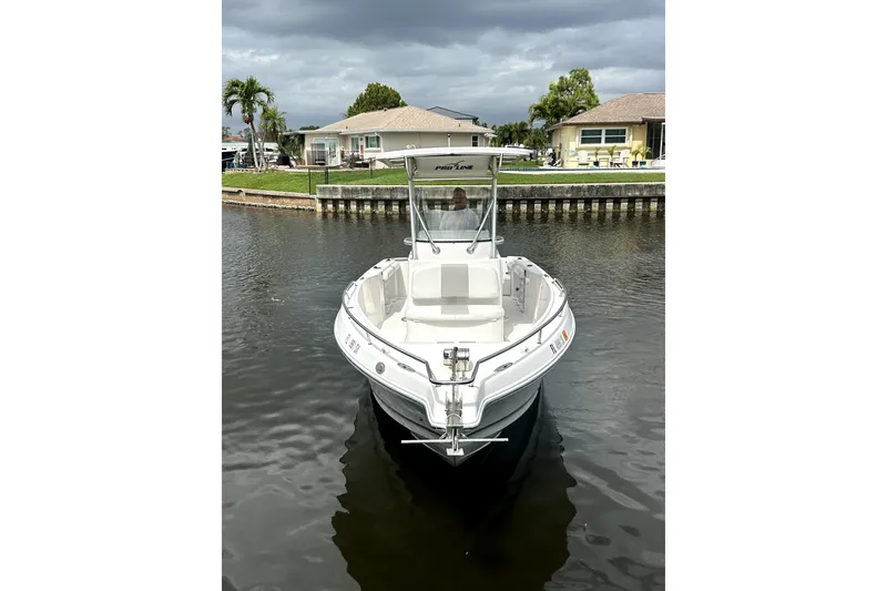 Slide: The Image of 2014 Pro-Line 26 Super Sport boat docked on a calm waterway. - 11