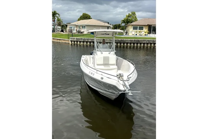 Slide: The Image of 2014 Pro-Line 26 Super Sport boat docked on a calm canal. - 13