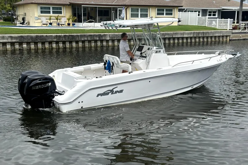 Slide: The Image of 2014 Pro-Line 26 Super Sport boat cruising on a calm waterway. - 16