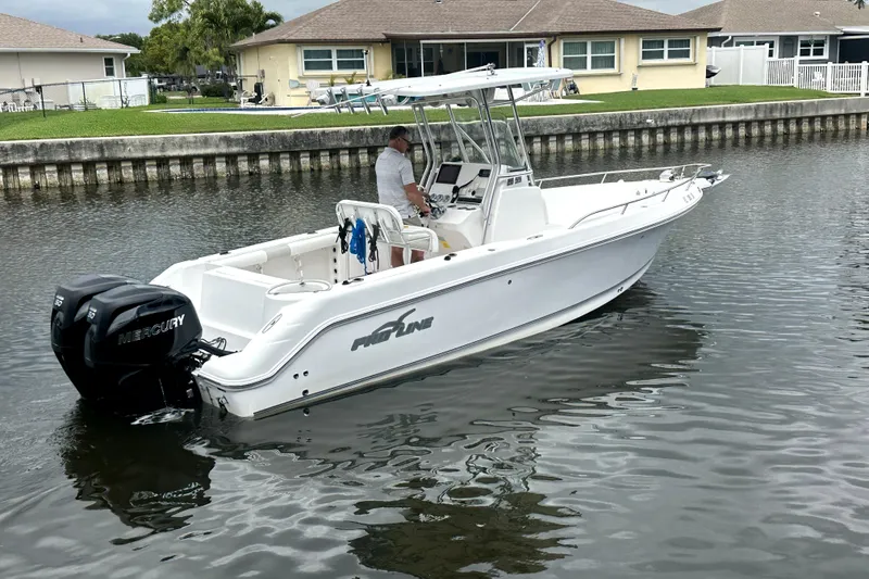 Slide: The Image of 2014 Pro-Line 26 Super Sport boat on calm water near residential area. - 18