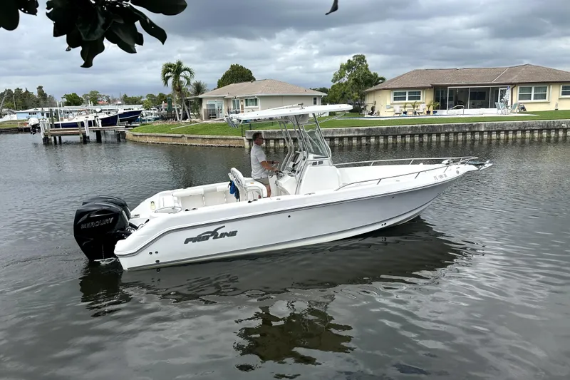 Slide: The Image of 2014 Pro-Line 26 Super Sport boat cruising on a calm residential canal. - 19