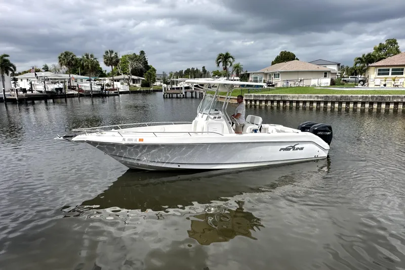 Slide: The Image of 2014 Pro-Line 26 Super Sport boat on calm water, cloudy sky background. - 2