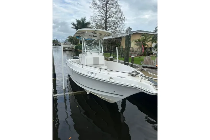 Slide: The Image of 2014 Pro-Line 26 Super Sport boat docked on a calm waterway. - 21
