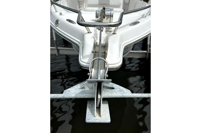 Slide: The Image of 2014 Pro-Line 26 Super Sport boat with anchor, docked on calm water. - 26
