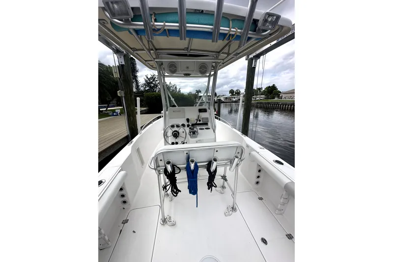 Slide: The Image of 2014 Pro-Line 26 Super Sport boat interior with helm and seating, docked by the water. - 38