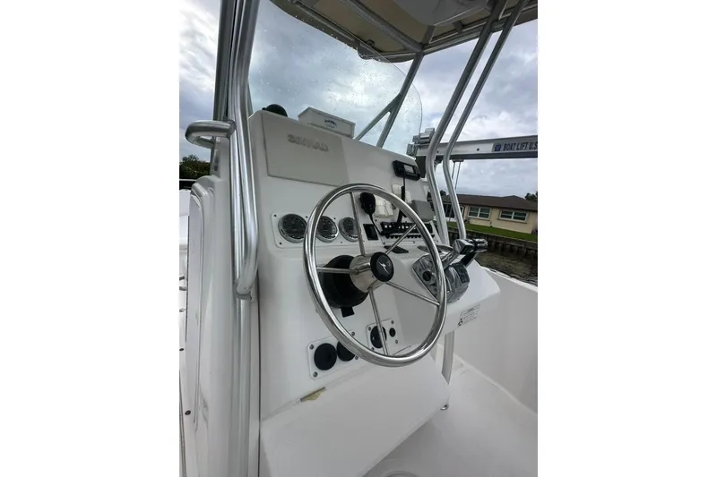 Slide: The Image of 2014 Pro-Line 26 Super Sport boat helm with steering wheel and controls. - 39
