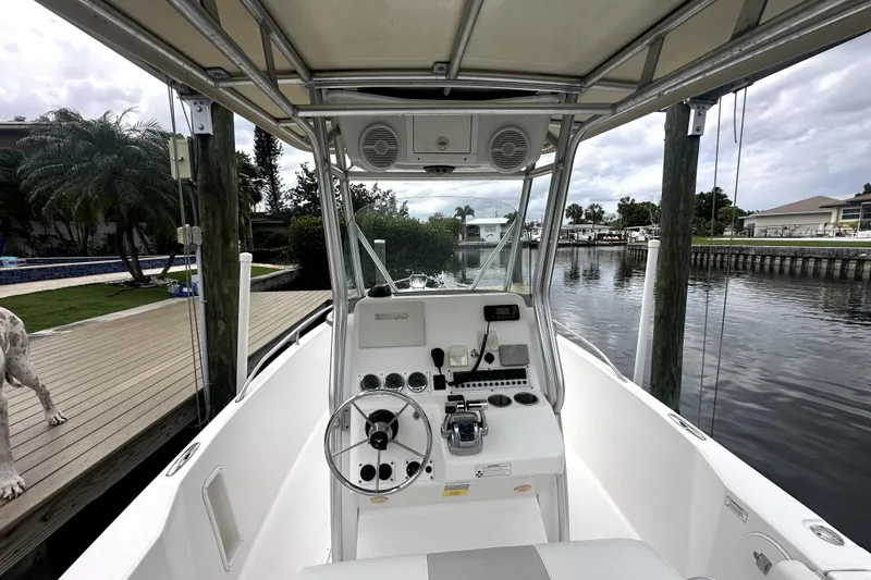 Slide: The Image of 2014 Pro-Line 26 Super Sport boat interior with steering wheel and controls, dockside view. - 40